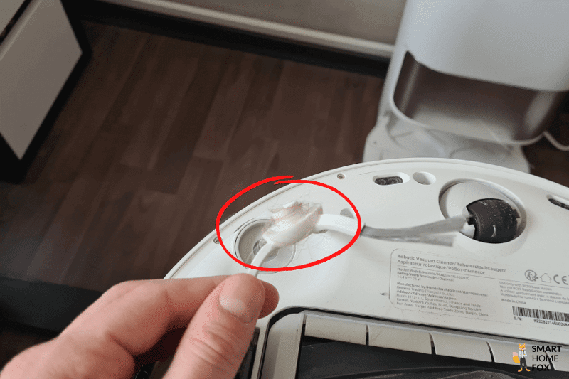 Festsitzende Haare werden aus der Seitenbürste des Dreame L10s Ultra entfernt.